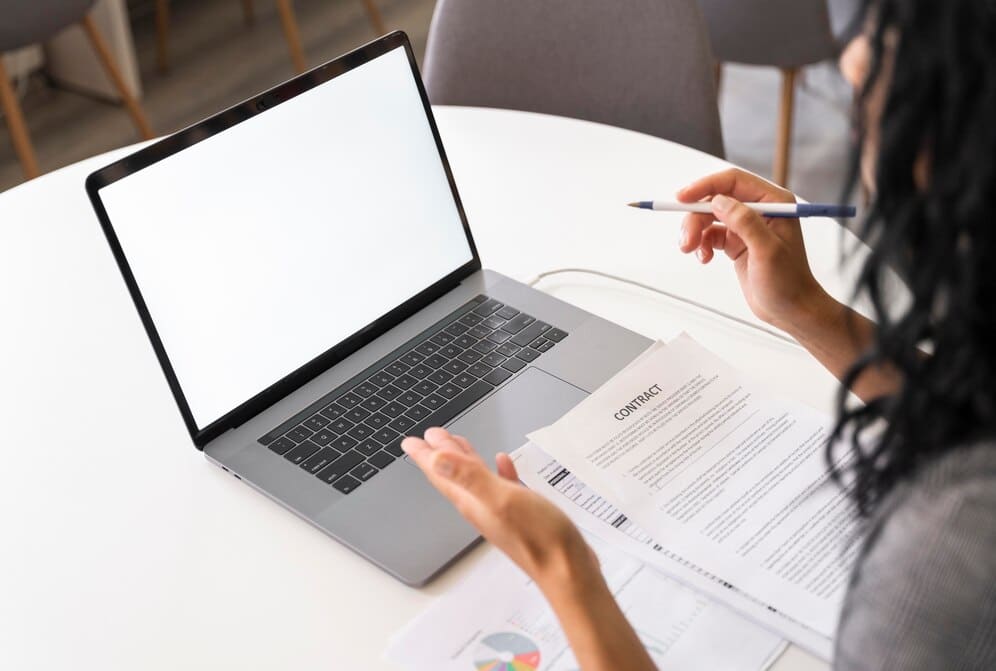 close-up-woman-holding-pen and working on laptop
